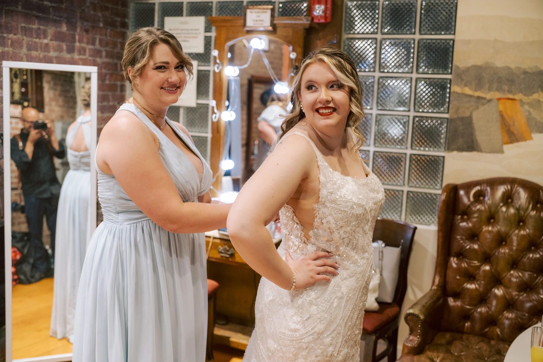 Bride and bridesmaid posing together in a bridal suite, both smiling at the camera. — Wedding at Dramatic Hall, peekskil, ny