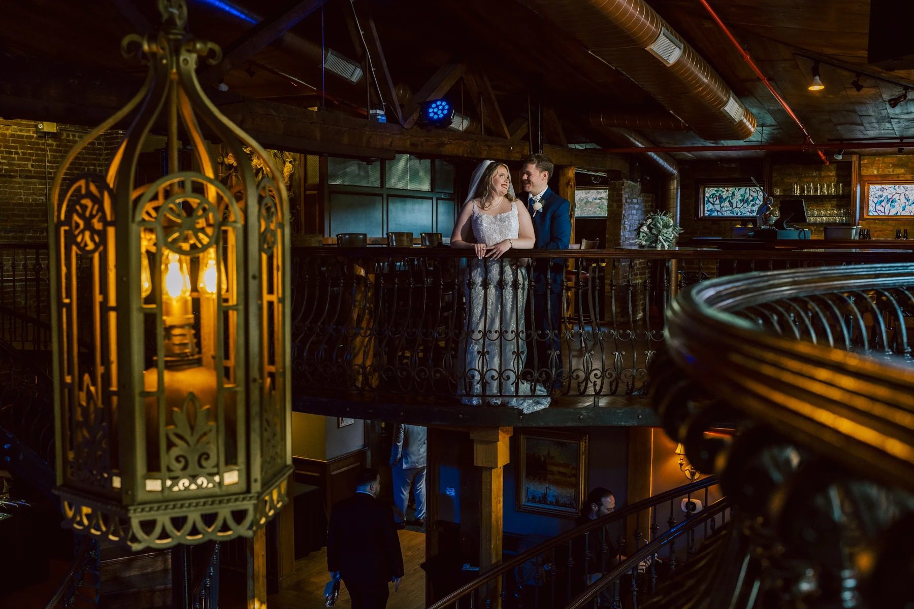 Bride and groom posing together on an ornate mezzanine balcony during evening reception. — Wedding at Dramatic Hall, peekskil, ny
