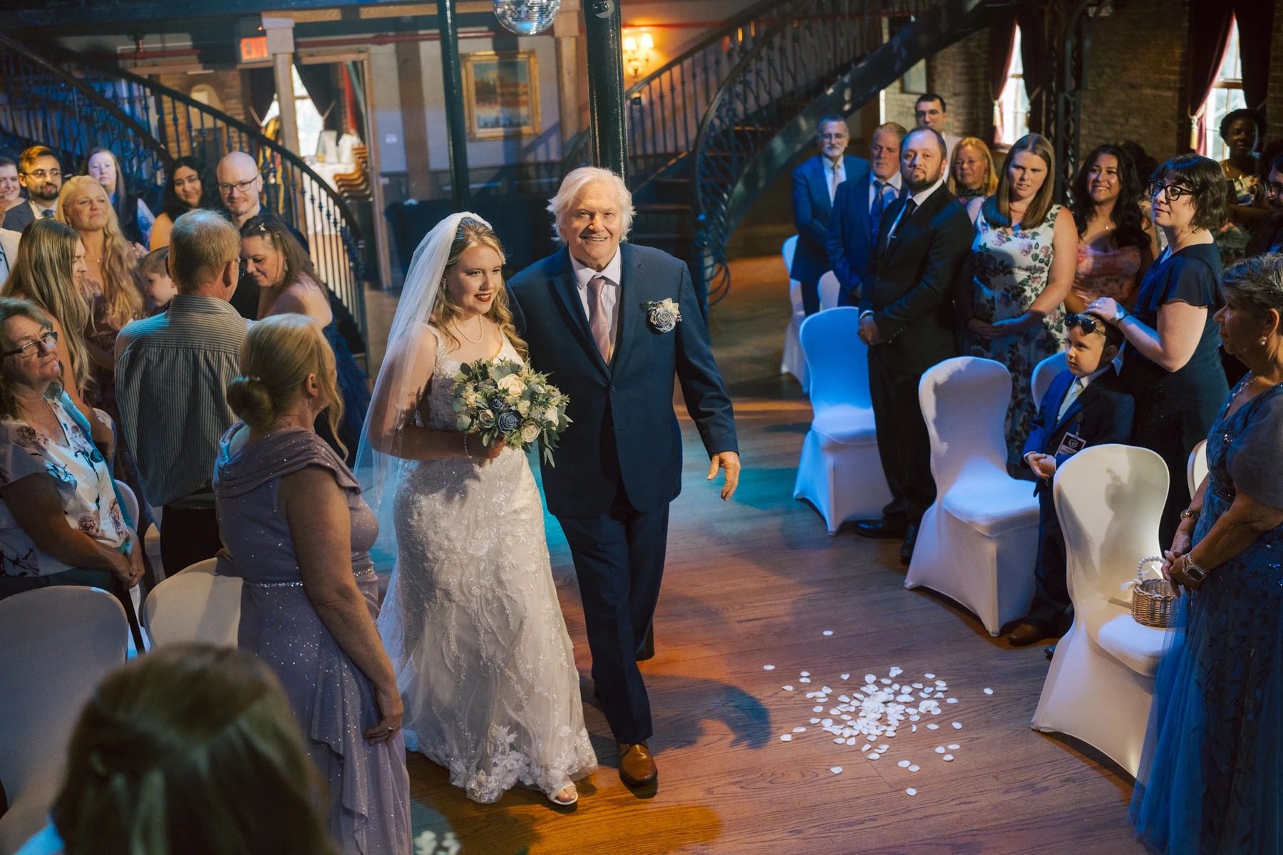 Bride and groom walk down the aisle together as guests stand and watch during the ceremony recessional. — Wedding at Dramatic Hall, peekskil, ny