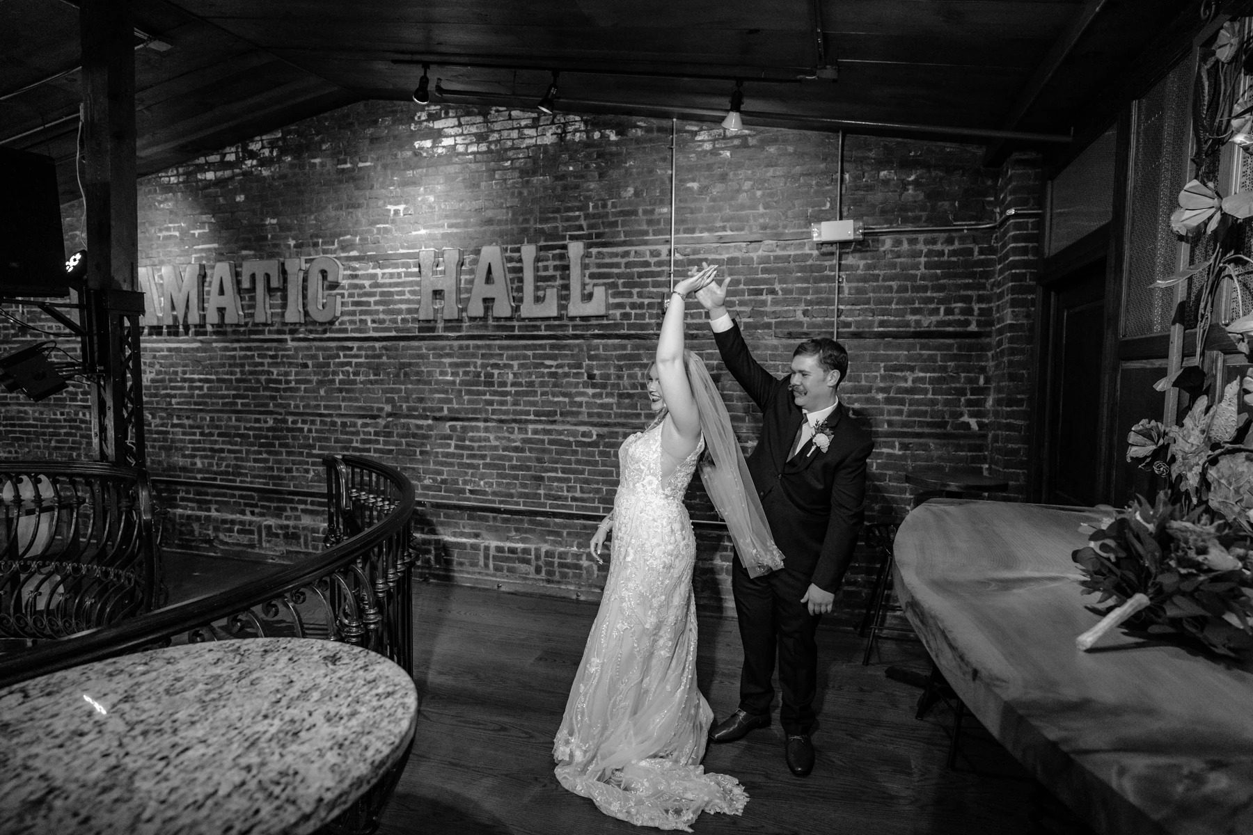 Groom twirling bride in her wedding dress inside an industrial brick venue — Wedding at Dramatic Hall, peekskil, ny