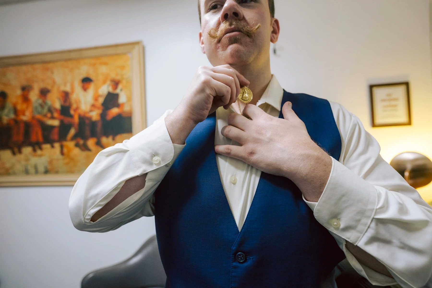 Man fastening his cufflink while adjusting his tie and vest before an event. — Wedding at Dramatic Hall, peekskil, ny
