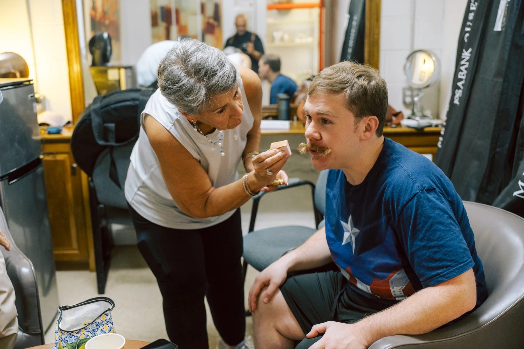 An older woman instructs a young man on boxing technique while he sits in a boxing ring. — Wedding at Dramatic Hall, peekskil, ny