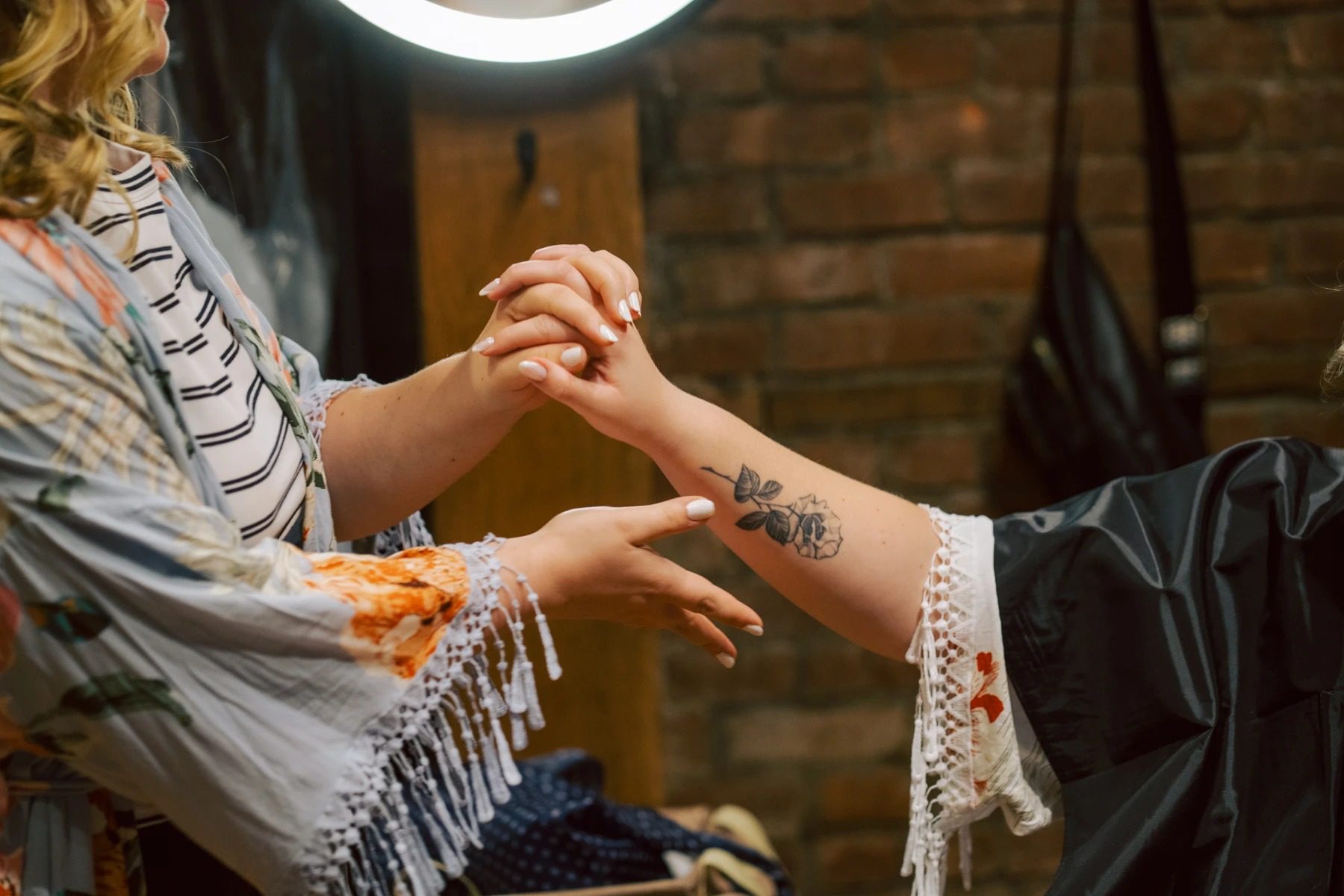 Two people joining hands together in an intimate gesture, one wearing a striped shirt with fringe. — Wedding at Dramatic Hall, peekskil, ny