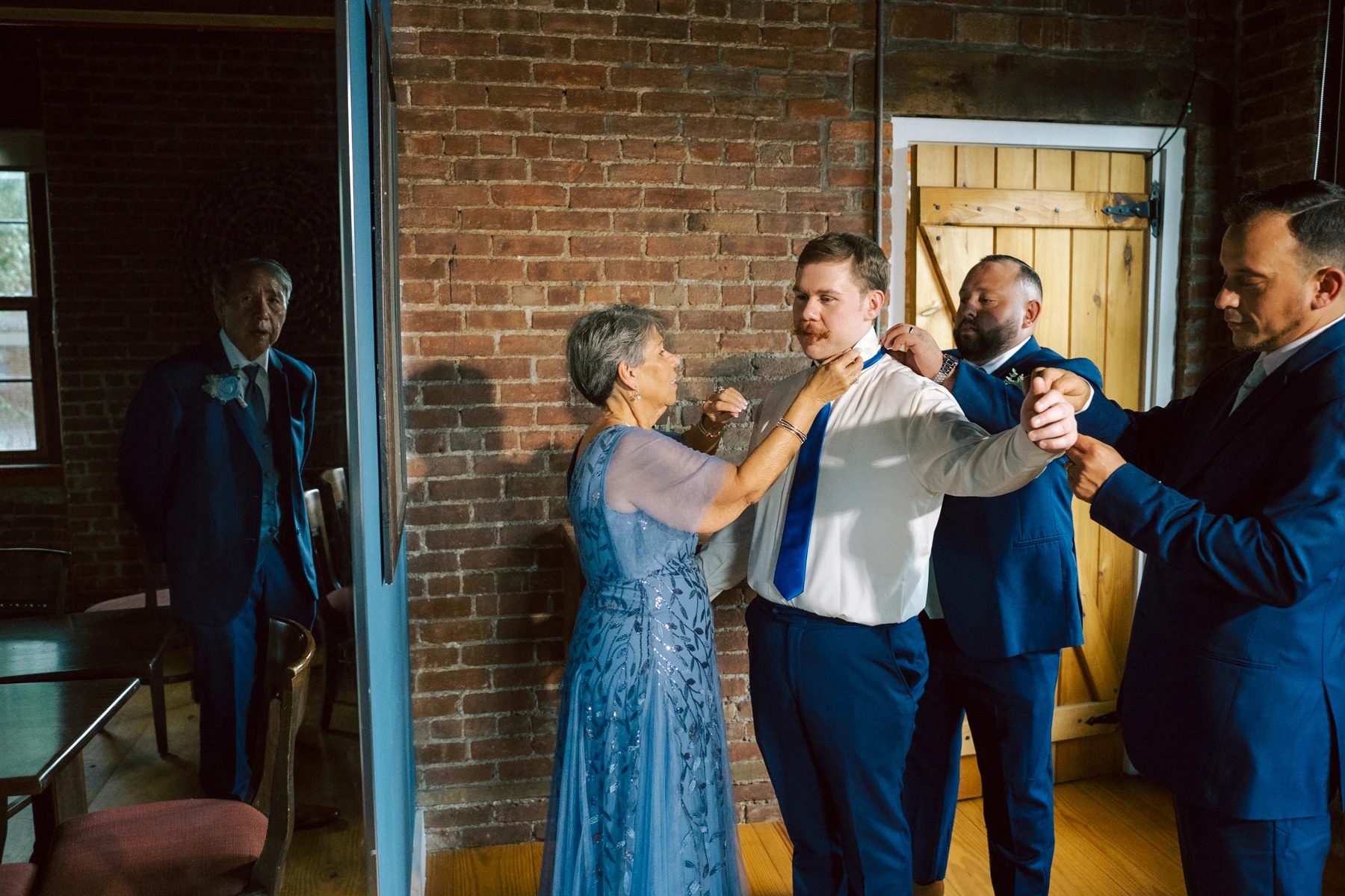 Woman in blue dress dancing with man in navy suit while guests watch in brick-walled room. — Wedding at Dramatic Hall, peekskil, ny