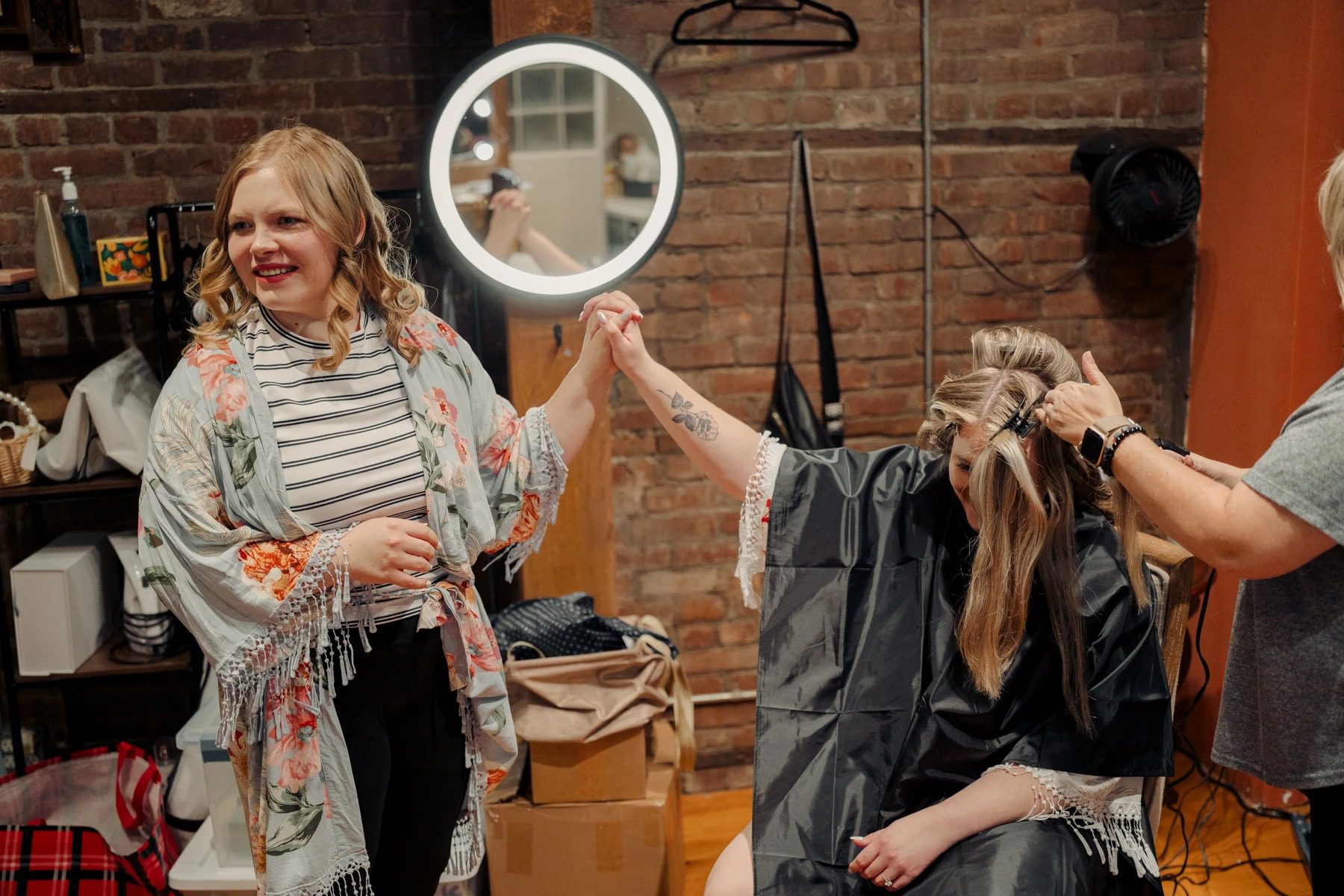 Woman holding up a circular mirror while another person adjusts her long hair during a getting-ready session. — Wedding at Dramatic Hall, peekskil, ny